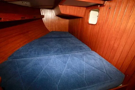 Slide: The Image of Interior cabin of 1981 Ta-Shing Panda 40 sailboat with blue cushions and wooden paneling. - 52