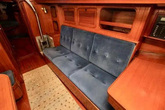 Slide: The Image of 1981 Ta-Shing Panda 40 yacht interior with blue cushioned seating and wooden cabinetry. - 60