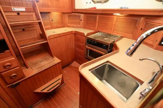 Slide: The Image of 1981 Ta-Shing Panda 40 yacht interior with wooden cabinetry, sink, and stove. - 65