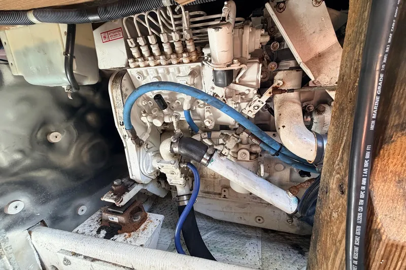 Slide: The Image of Engine compartment of a 1997 H&H Marine 38 boat, featuring hoses and mechanical components. - 22