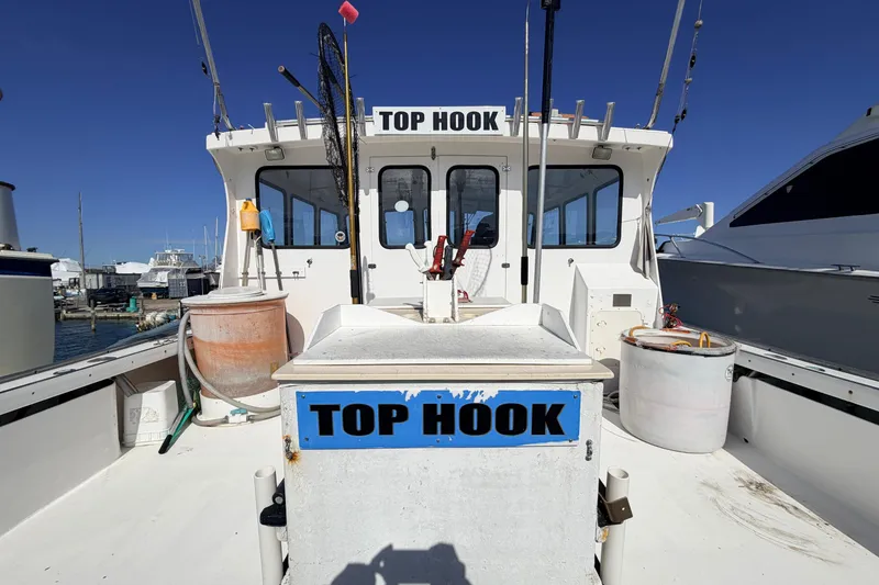 Slide: The Image of 1997 H&H Marine 38 boat named "Top Hook" docked at a marina under clear blue skies. - 35