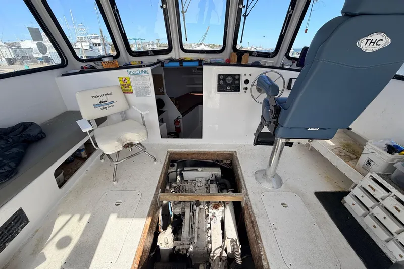 Slide: The Image of Interior of a 1997 H&H Marine 38 boat, showcasing helm and engine compartment. - 5