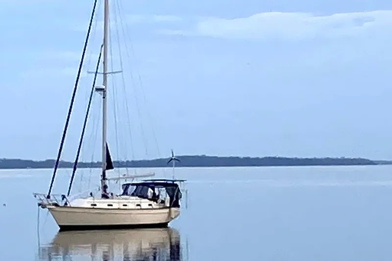 Slide: The Image of Island Packet 380 sailboat from 2002 anchored on calm water under a clear sky. - 11