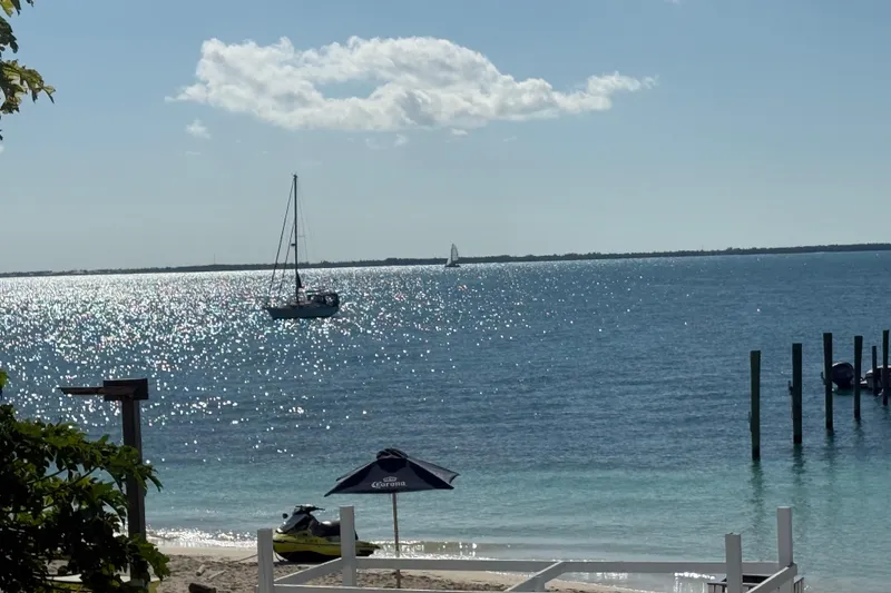 Slide: The Image of Sailboat on sparkling ocean near beach, Island Packet 380, 2002 model. - 12