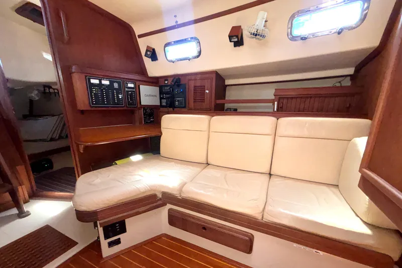Slide: The Image of Interior of 2002 Island Packet 380 sailboat with beige seating and navigation equipment. - 17