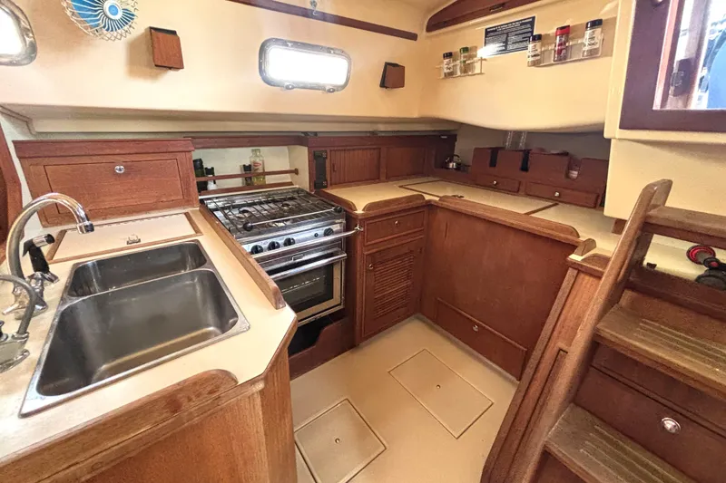 Slide: The Image of Interior of 2002 Island Packet 380 sailboat kitchen with wooden cabinetry and stainless steel sink. - 2