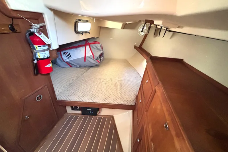 Slide: The Image of Cozy cabin interior of 2002 Island Packet 380 sailboat with wooden cabinetry and fire extinguisher. - 22
