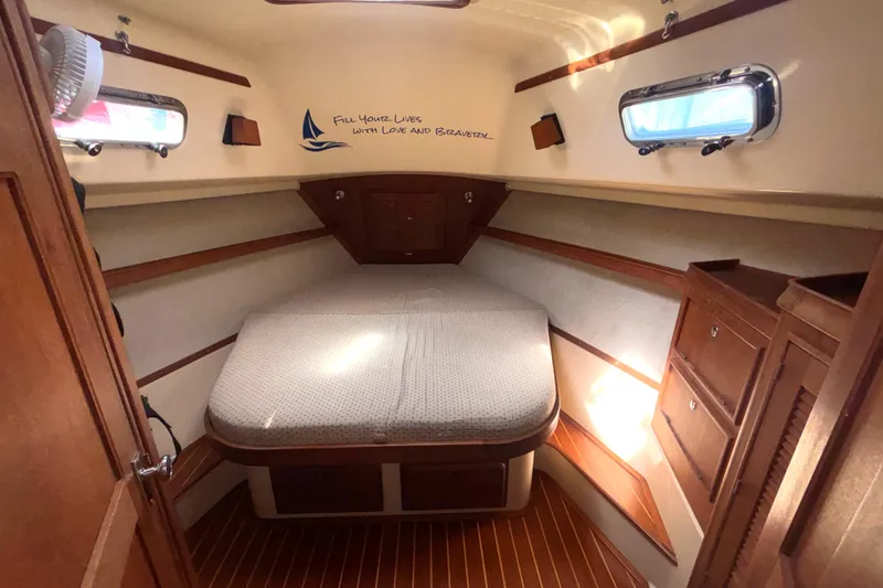 Slide: The Image of Cozy cabin interior of 2002 Island Packet 380 sailboat with bed and wooden cabinetry. - 23