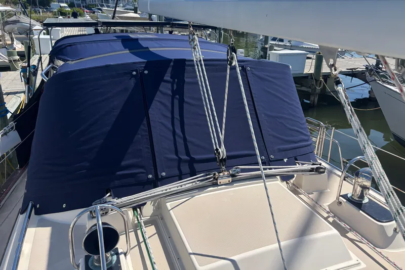 Slide: The Image of 2002 Island Packet 380 sailboat with blue canvas cover at marina. - 25