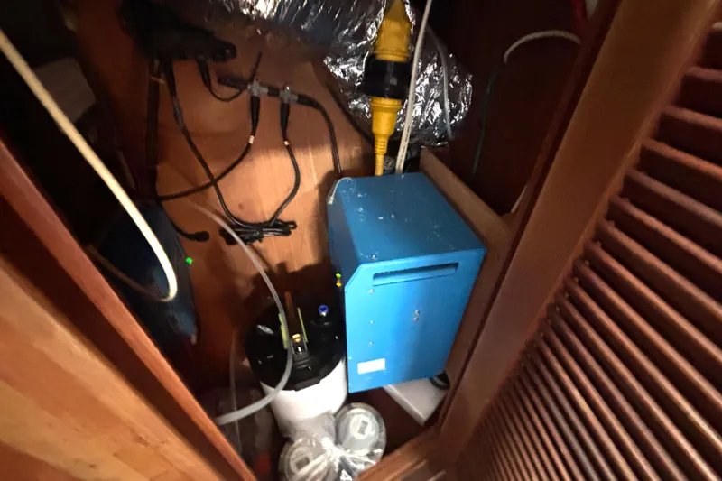 Slide: The Image of Electrical setup inside a 2002 Island Packet 380 sailboat, featuring wiring and equipment. - 34