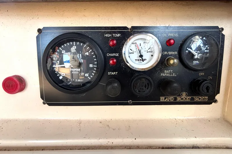 Slide: The Image of Control panel of a 2002 Island Packet 380 yacht with RPM, temperature, and oil gauges. - 44