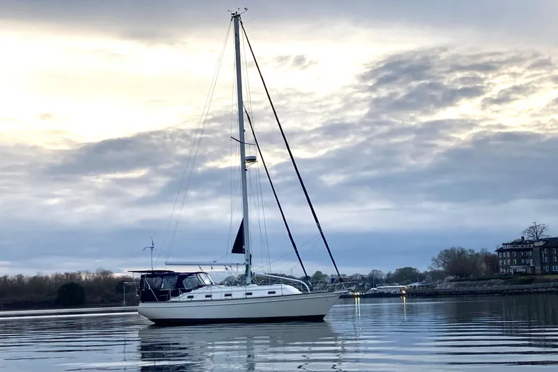 Slide: The Image of Sailboat Island Packet 380 (2002) on calm water at sunset. - 8