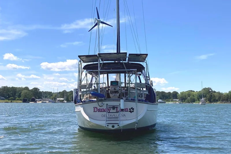 Slide: The Image of Sailboat "Island Packet 380" from 2002 on calm water, clear sky background. - 9