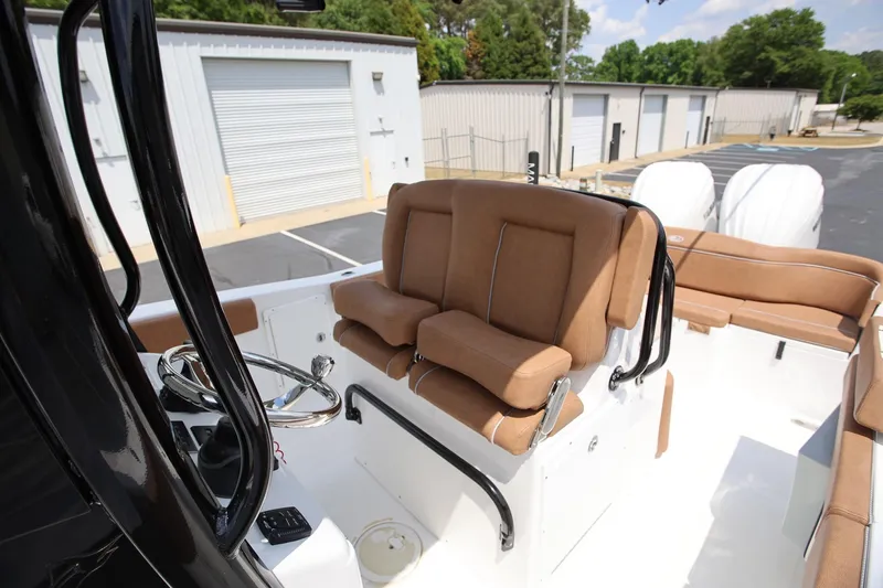 Slide: The Image of 2024 Sea Hunt Ultra 275 SE boat interior with tan seating and dual engines. - 11