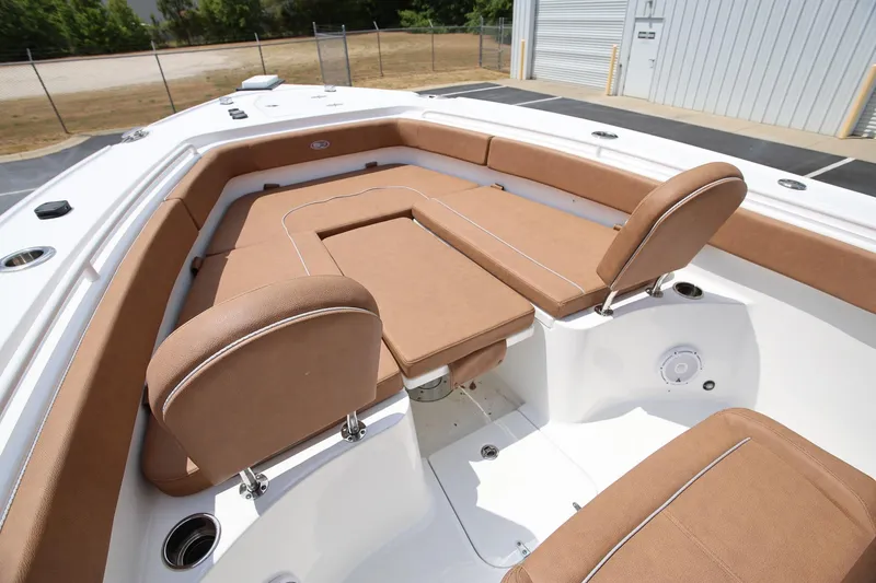 Slide: The Image of 2024 Sea Hunt Ultra 275 SE boat interior with tan cushioned seating and table. - 15
