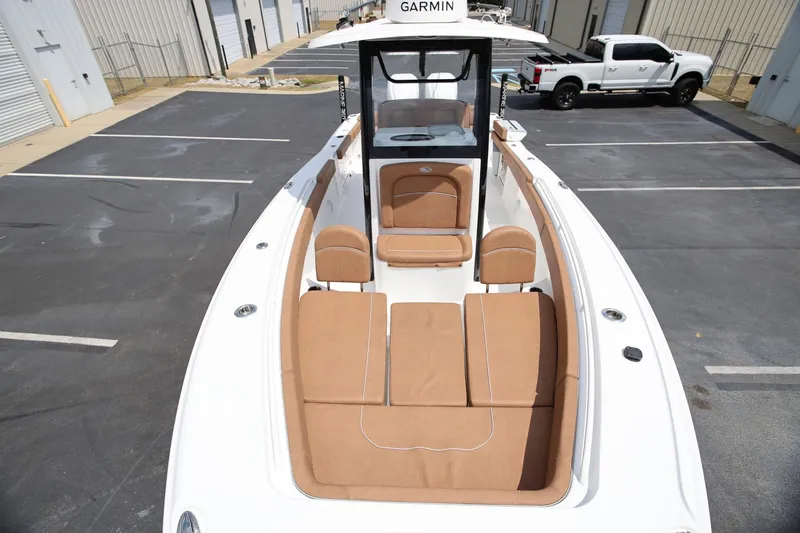 Slide: The Image of 2024 Sea Hunt Ultra 275 SE boat with tan seating, parked in a lot. - 16