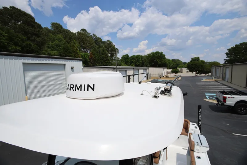 Slide: The Image of 2024 Sea Hunt Ultra 275 SE boat with Garmin radar, parked near storage units. - 23