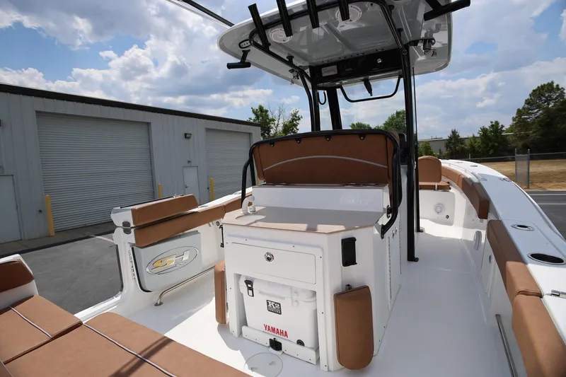 Slide: The Image of 2024 Sea Hunt Ultra 275 SE boat interior with seating and storage, parked outdoors. - 8