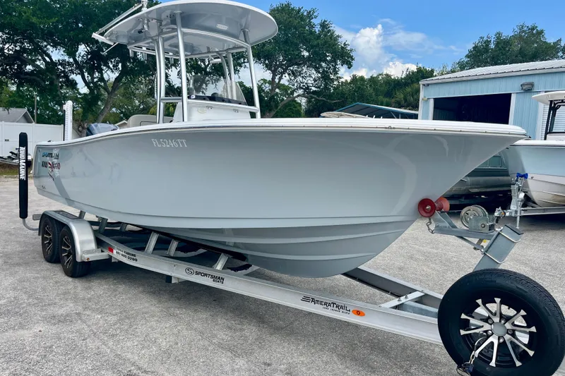 The Image of 2023 Sportsman Open 232 Center Console boat on trailer, parked outdoors. - 0