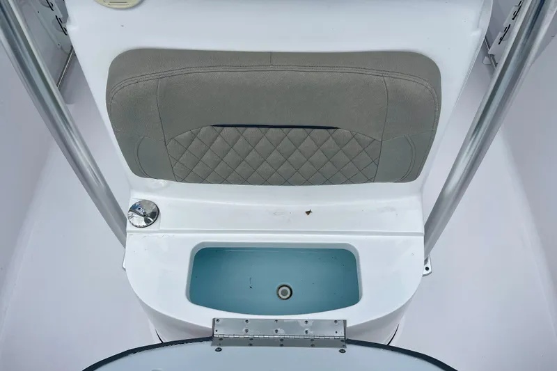 Slide: The Image of 2023 Sportsman Open 232 Center Console boat interior with cushioned seating and storage compartment. - 18
