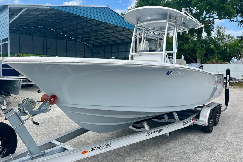 Slide: The Image of 2023 Sportsman Open 232 Center Console boat on trailer, parked under a metal canopy. - 2