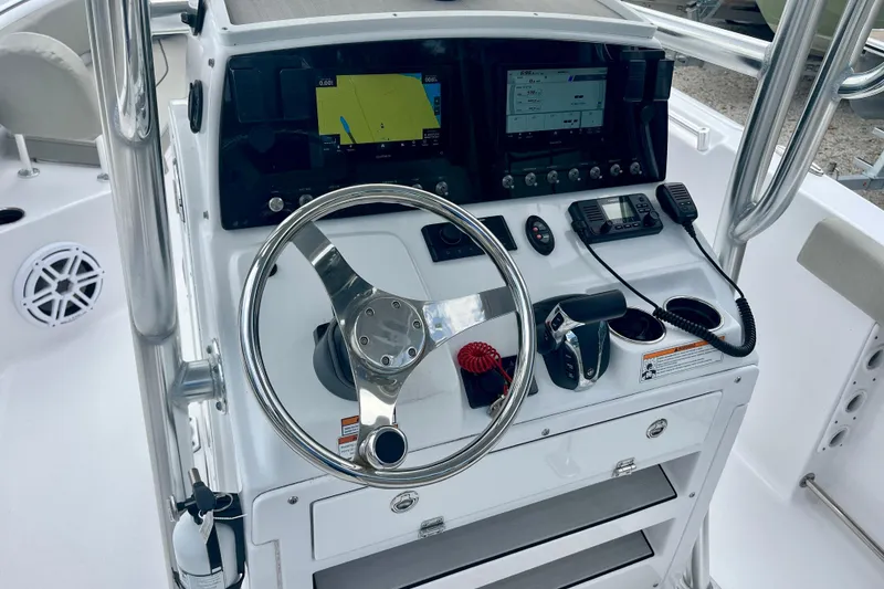Slide: The Image of 2023 Sportsman Open 232 Center Console boat dashboard with steering wheel and navigation controls. - 21