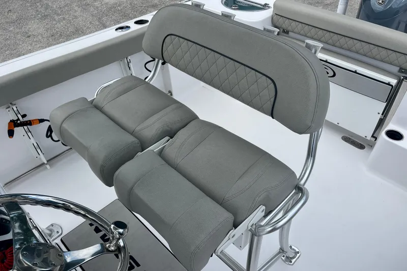 Slide: The Image of 2023 Sportsman Open 232 Center Console boat interior with cushioned seating and steering wheel. - 25