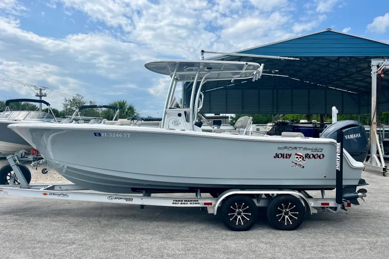 Slide: The Image of 2023 Sportsman Open 232 Center Console boat on trailer, featuring Yamaha engine, under blue sky. - 3