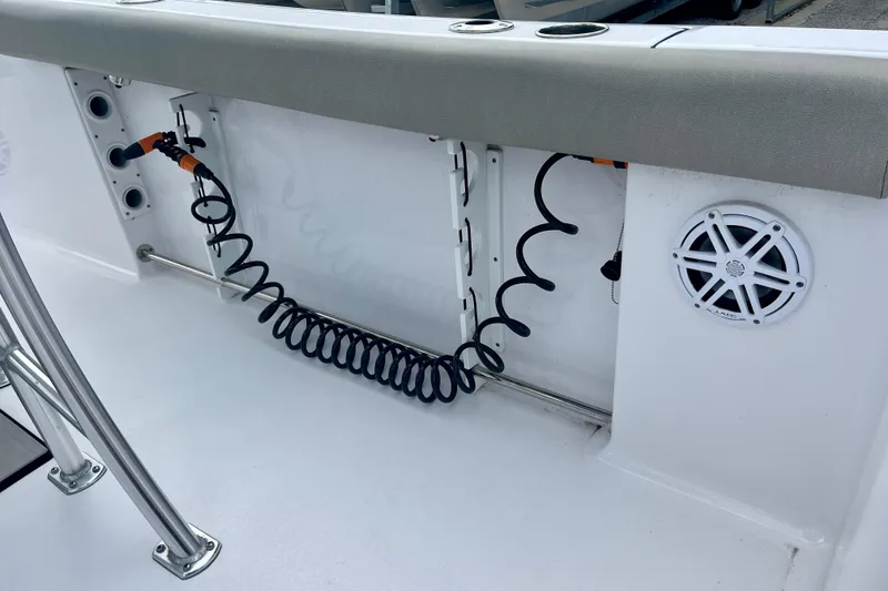 Slide: The Image of 2023 Sportsman Open 232 Center Console boat interior with coiled hose and speaker. - 9