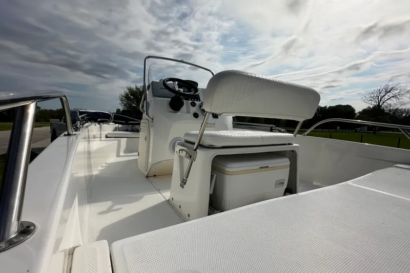 Slide: The Image of 2008 Boston Whaler 180 Dauntless boat interior with steering console and seating under cloudy sky. - 11