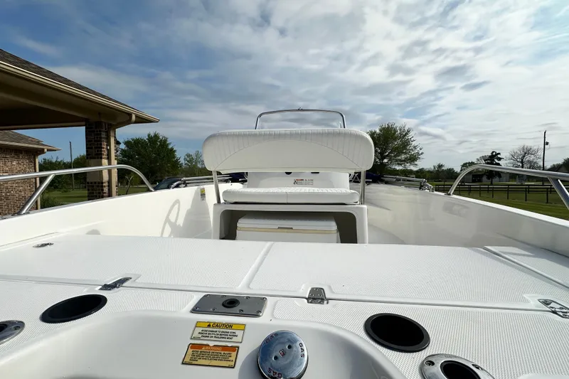 Slide: The Image of 2008 Boston Whaler 180 Dauntless boat interior with seating and storage, under a cloudy sky. - 18