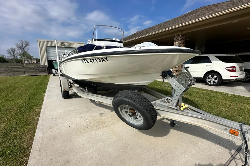 Slide: The Image of 2008 Boston Whaler 180 Dauntless boat on trailer, parked in driveway. - 2
