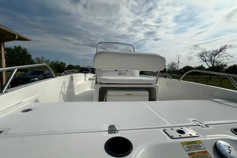 Slide: The Image of 2008 Boston Whaler 180 Dauntless boat interior with seating and storage, under a cloudy sky. - 20