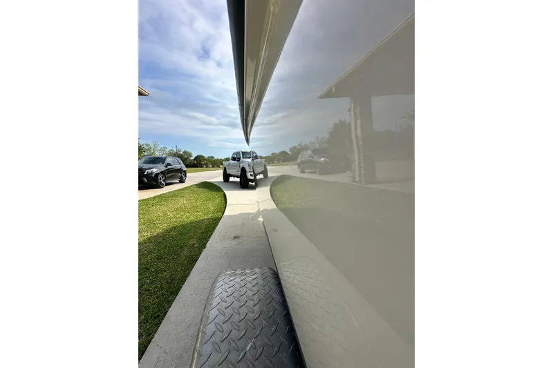 Slide: The Image of 2008 Boston Whaler 180 Dauntless boat on trailer, driveway reflection, clear sky. - 25