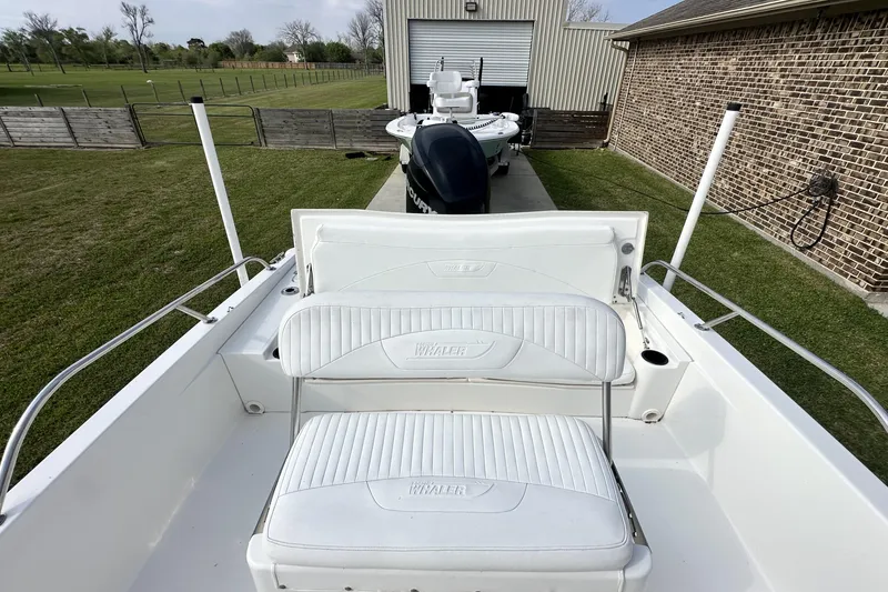 Slide: The Image of 2008 Boston Whaler 180 Dauntless boat with white seating, parked near a garage. - 37