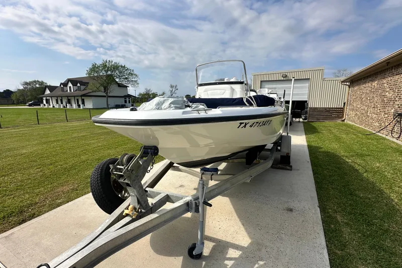 Slide: The Image of 2008 Boston Whaler 180 Dauntless boat on trailer, parked in driveway near house. - 4