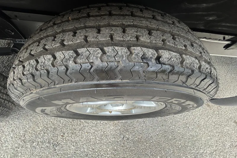 Slide: The Image of 2008 Ranger Z22 Comanche boat with Mercury engine, parked near a metal building. - 28