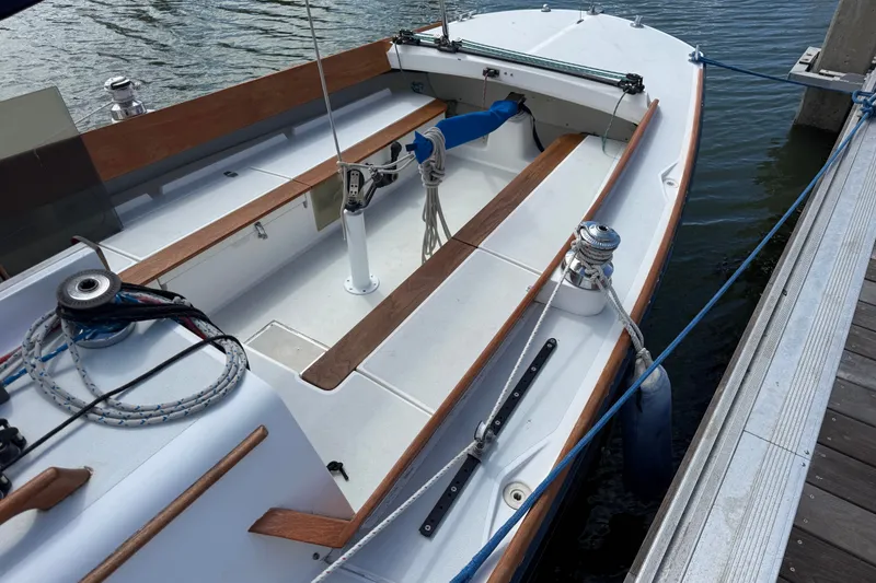 Slide: The Image of 2003 Alerion Express 28 sailboat docked, featuring a clean deck and wooden accents. - 9