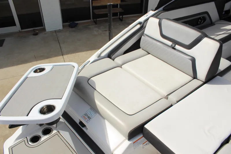 Slide: The Image of 2020 Yamaha Boats 275SE interior with cushioned seating and built-in cup holders. - 10