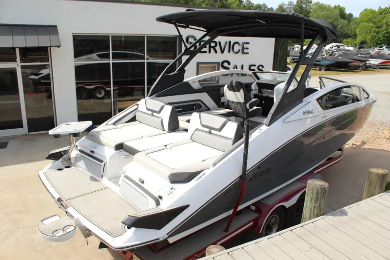 Slide: The Image of 2020 Yamaha Boats 275SE on trailer, sleek design, white and gray exterior, at service and sales center. - 3