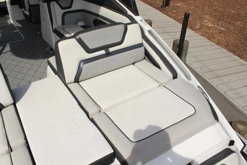 Slide: The Image of 2020 Yamaha Boats 275SE interior seating with sleek white and black design. - 9