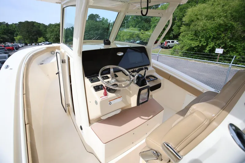 Slide: The Image of 2018 Scout 300 LXF boat interior with steering wheel and control panel. - 18