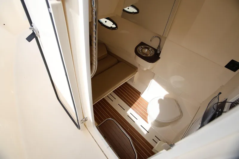 Slide: The Image of 2018 Scout 300 LXF boat interior with sink, toilet, and wooden flooring. - 19