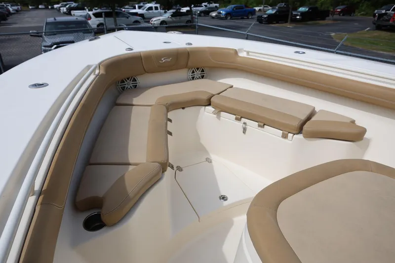 Slide: The Image of 2018 Scout 300 LXF boat interior with tan cushioned seating and speakers. - 21