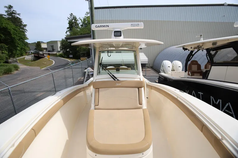 Slide: The Image of 2018 Scout 300 LXF boat with Garmin equipment, docked near a warehouse. - 23