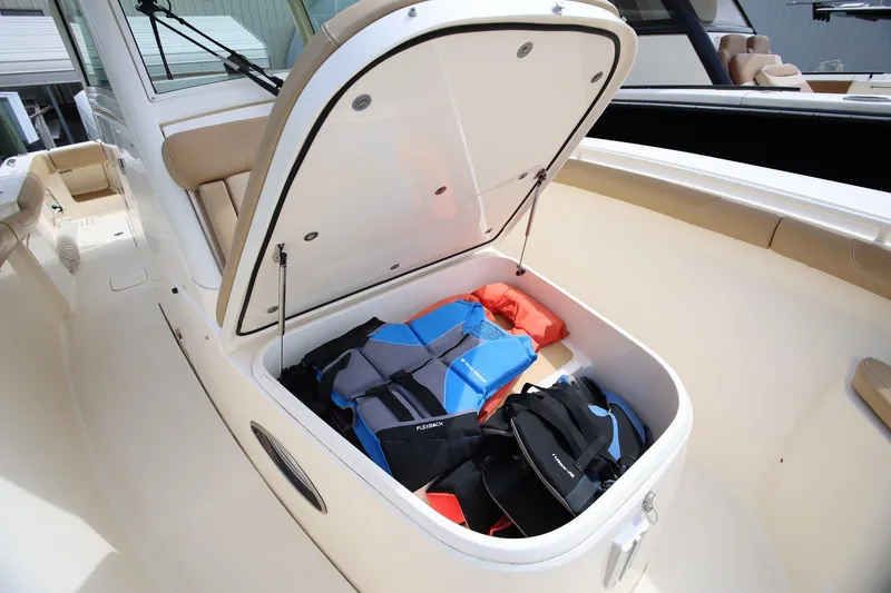 Slide: The Image of 2018 Scout 300 LXF boat storage compartment with life jackets and gear. - 24