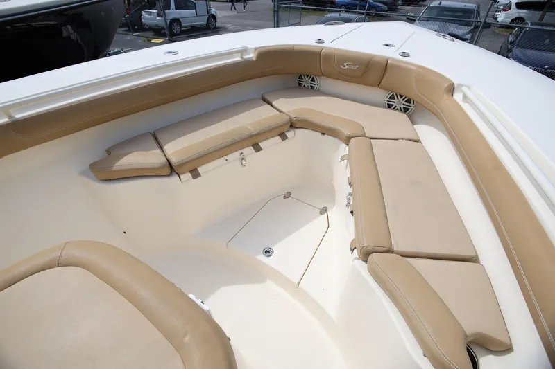 Slide: The Image of 2018 Scout 300 LXF boat interior with tan cushioned seating and speakers. - 25