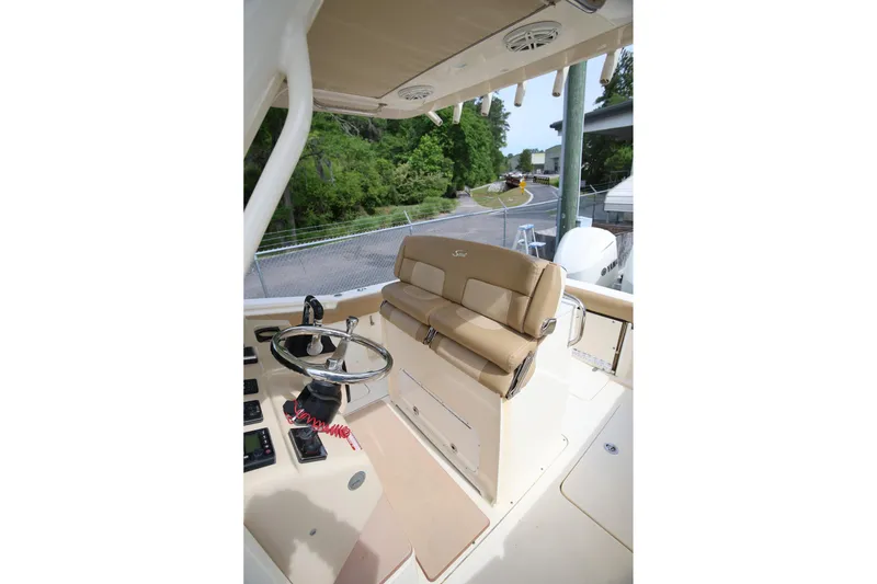 Slide: The Image of 2018 Scout 300 LXF boat interior with steering wheel and beige seating. - 36
