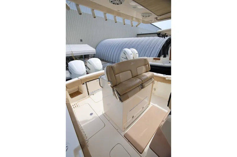 Slide: The Image of 2018 Scout 300 LXF boat interior with tan seating and dual outboard engines. - 37
