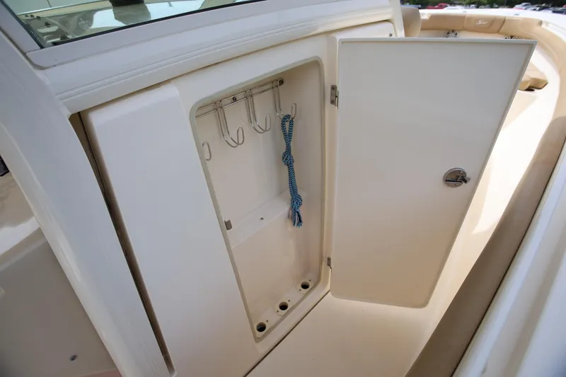 Slide: The Image of 2018 Scout 300 LXF boat storage compartment with hooks and rope. - 38